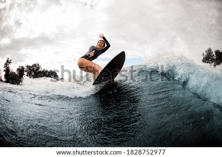 Similar – Image, Stock Photo Surfer woman with wetsuit and surfboard looking at the sea