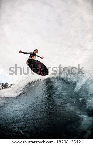 Similar – Image, Stock Photo Surfer woman with wetsuit and surfboard looking at the sea