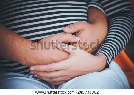 men holds hands on belly of pregrant women no face