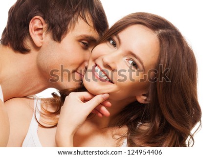 Young adult woman smiling and holding hand near mouse with boyfriend kissing her