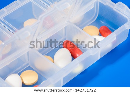 Close-up of open dosage plastic container full of different drugs for different days