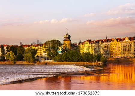 Vltava river in Prague near Slovansky island with houses and tower