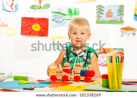 2 years old happy boy in the preschool art class  with pencils toys and blocks