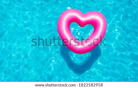 Inflatable rose heart buoy swim in the swimming pool view from above