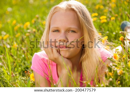Blond cute girl in yellow flowers portrait