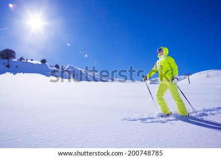 Young skier in bright clothes the first one to concur new snow terrain