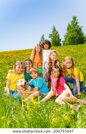 Happy children with dog together in meadow