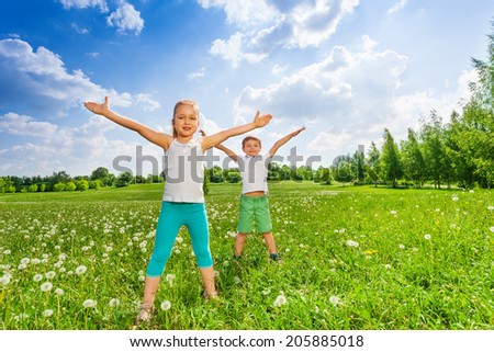 Two kids doing outdoor gymnastics on the grass