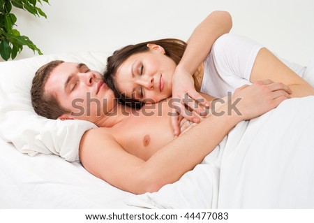 Couple sleep in the bed and and smile in home interior