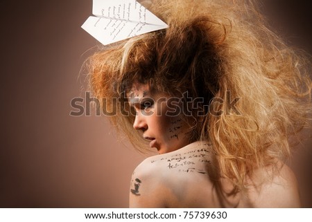 Beauty shoot of a woman with words of love on her face and on paper plane with professional make up and hairstyle (words, printed on a plane was made up for this look)