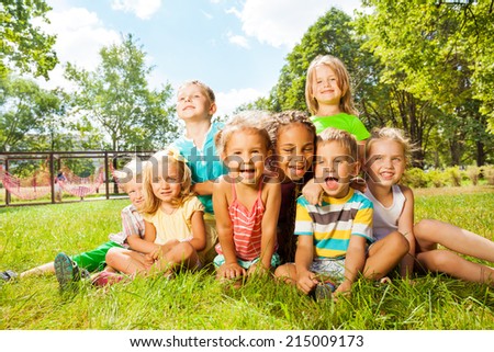 Group of happy little kids on the lawn in park