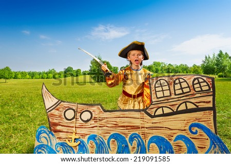 Angry boy in pirate costume shouts and holds sword