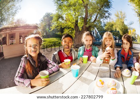 Happy group of international children drinking tea