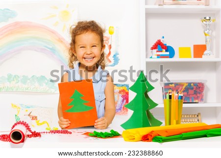 Laughing girl holding carton card with Xmas tree