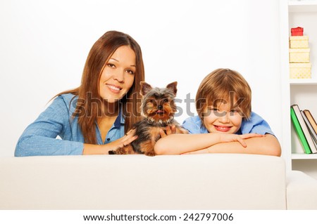 Mother with her son and Yorkshire dog lay on sofa