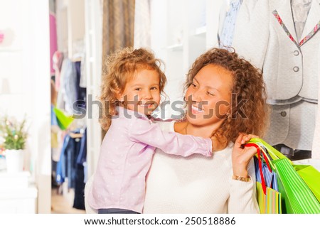 Small cute girl with her beautiful mother shopping