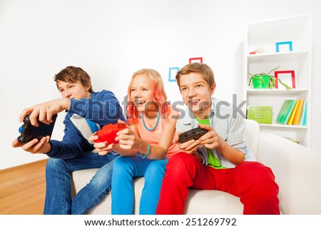 Girl and boys with joysticks playing game console