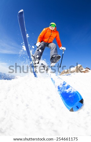 Young man in a jump while skiing view from below