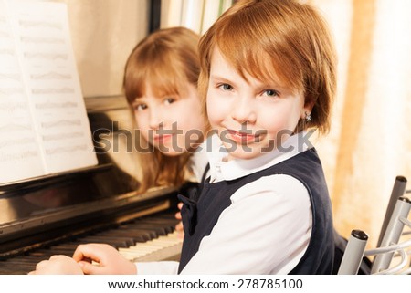 Close-up view of two small girls playing piano