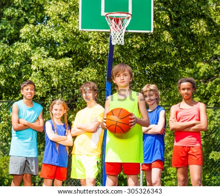 Boy with his team behind during basketball game