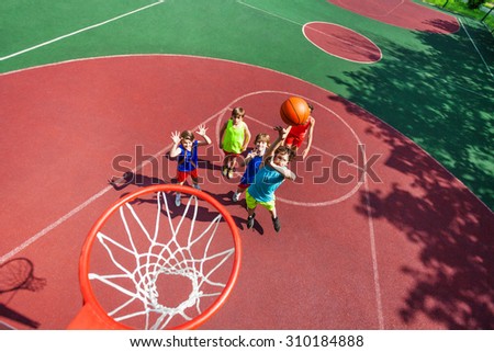 Kids stand on ground and ball flying to the basket