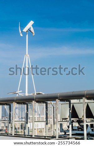 Vertical wind turbine on factory roof on blue sky background.\
Vertical wind turbine on factory roof.