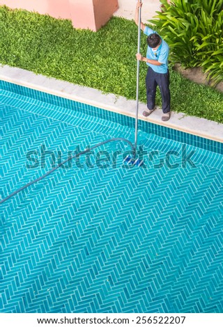 Aerial view of pool guy cleaning in the early morning. \
Worker cleaning the pool.