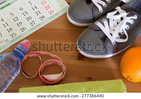 set for sports activities. Set for preparation for weight loss, running shoes, water, orange, calendar, towel