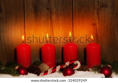Advent candles with snow in front of wood background