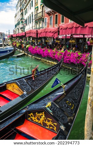 VENICE, ITALY - JUNE 26, 2014: Tourists travel on gondolas at canal Venice, Italy . Gondola trip is the most popular touristic activity in Venice.