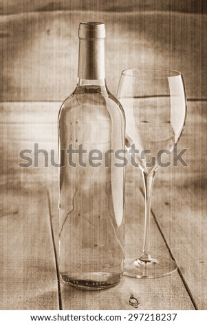 bottle of dry white wine with a glass. Old style, sepia