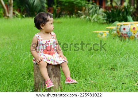 baby girl sitting on wooden chair and think \