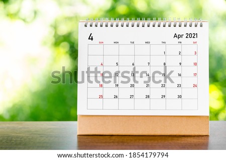 April 2021 Calendar desk for organizer to plan and reminder on wooden table on nature background.