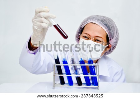 Focused young life science professional pipetting solution into the glass cuvette. Lens focus on the researcher\'s eye.
