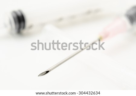Medical needle and syringe on white background.