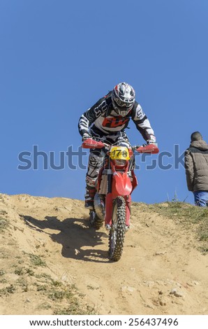 GUADALAJARA, SPAIN - FEBRUARY 22th 2015: Spain cross country championship. Unknown biker is going down a slope with his motorcycle, during first race of 2015, in Guadalajara, on February 22th 2015.