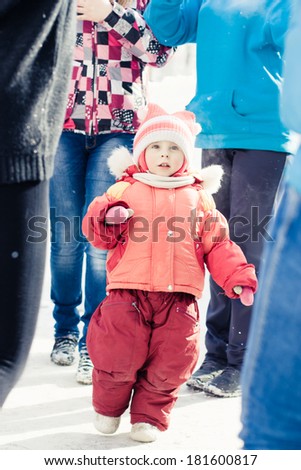 Small child lost in a crowd of strangers in winter