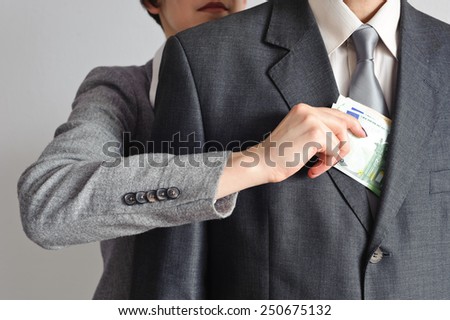 Female hand pulls money from the men of the jacket