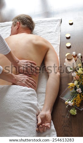 Back Massage. Woman doing massage to man. Her hand on his back