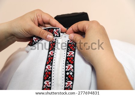 Female tailor captures shirt collar using pin