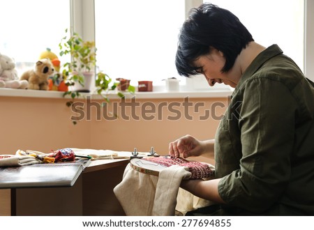 Women embroidering on embroidery frame (cross-stitch)