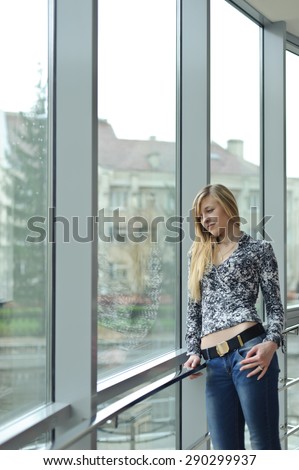 Young beautiful woman standing near a large window