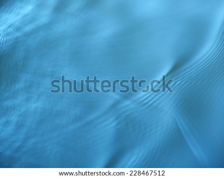 Blue sky reflected on gentle water ripples.