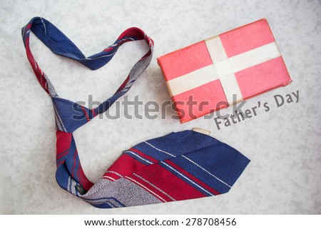 Fathers Day gifts with tag and tie over a white background