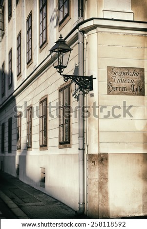 Vintage style photo of an old lantern at the corner of the street. The street sign in old croatian and german languages reads \