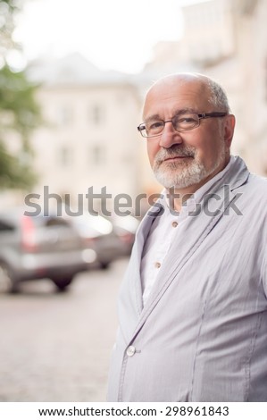 solid smiling man in the city on the background of cars and houses
