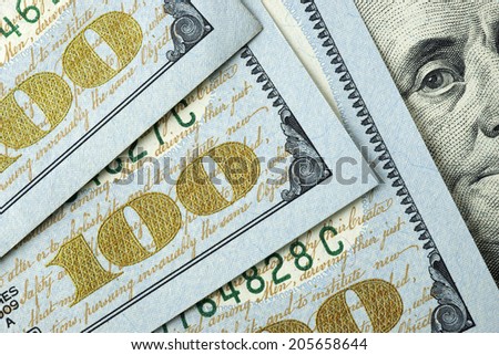 Hundred dollar bills with a close up of Benjamin Franklin\'s eyes.