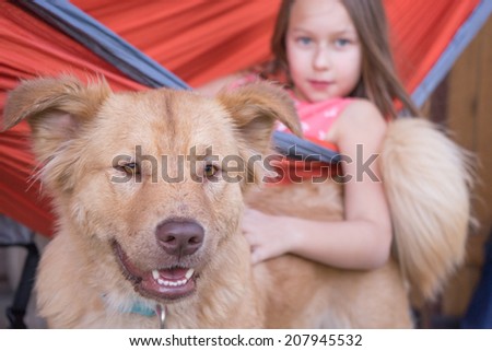 Girl in hammock petting her dog
