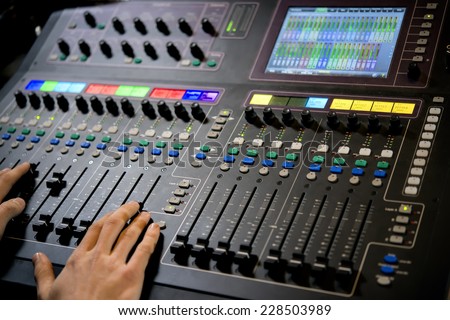 Professional control panel with operator hands in the recording studio
