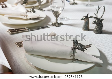 White clean plate with a napkin on which to lay the table covered with a white tablecloth